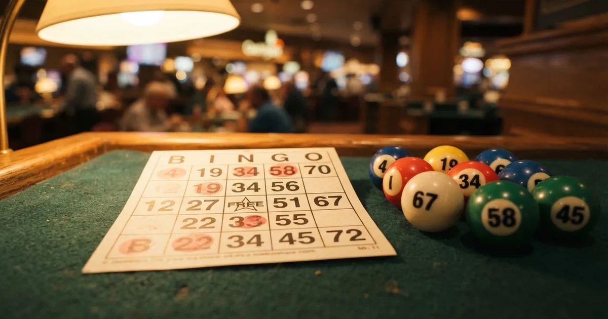 Karta do bingo z odznaczonymi liczbami obok wylosowanych kulek na stole w kasynie online